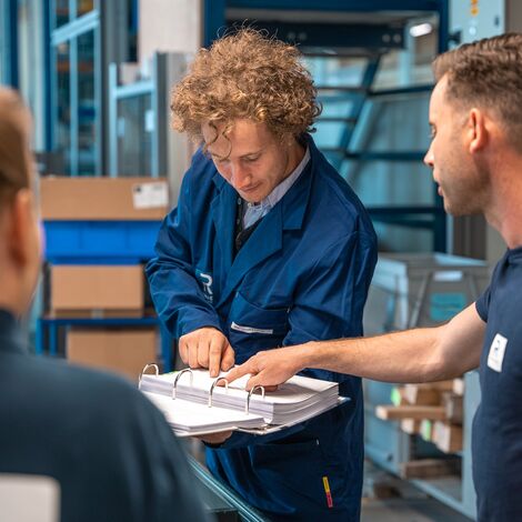 Professional trainer guiding new Reynaers Aluminium employees through the catalogue.